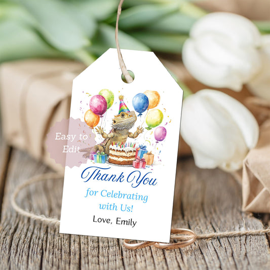 Gift tag with a lizard celebrating birthday, surrounded by flowers on a wooden surface.