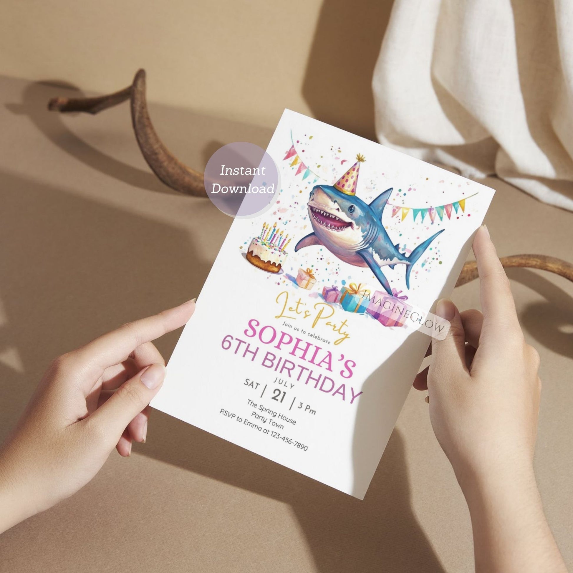 Person holding a shark-themed birthday party invitation with colorful graphics.