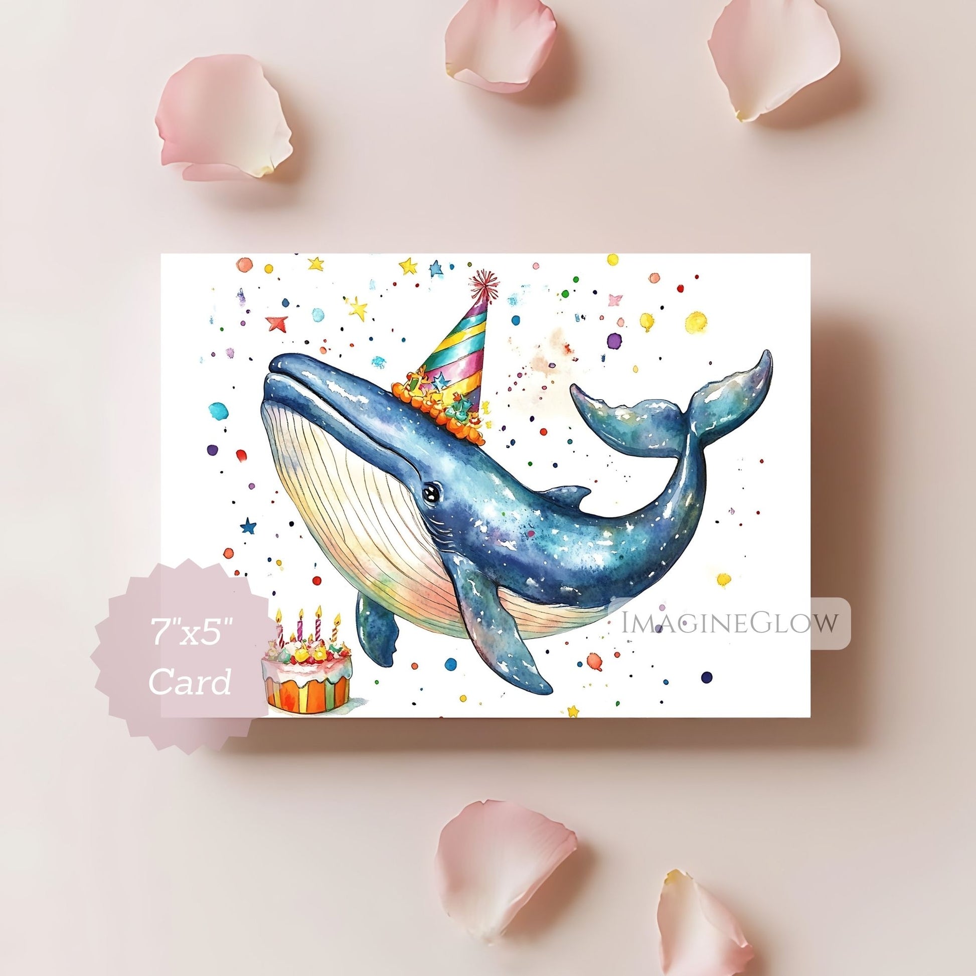 Colorful whale illustration on a card with birthday cake and party hat, surrounded by pink petals.