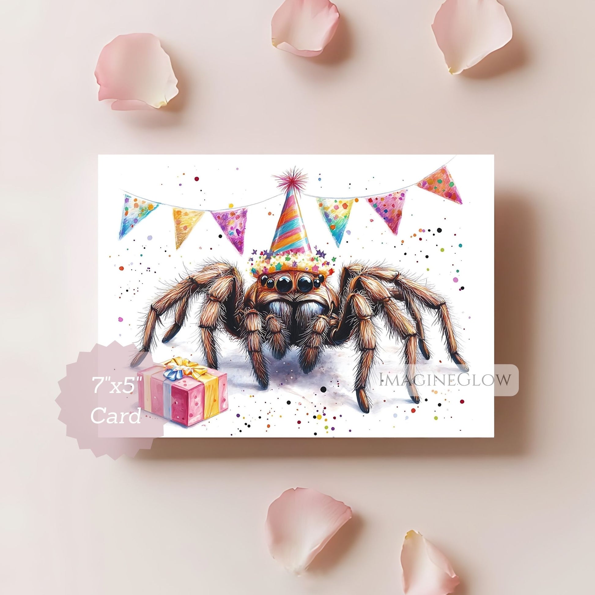Card with a spider wearing a party hat and surrounded by colorful flags and a gift, on a light pink background with rose petals.