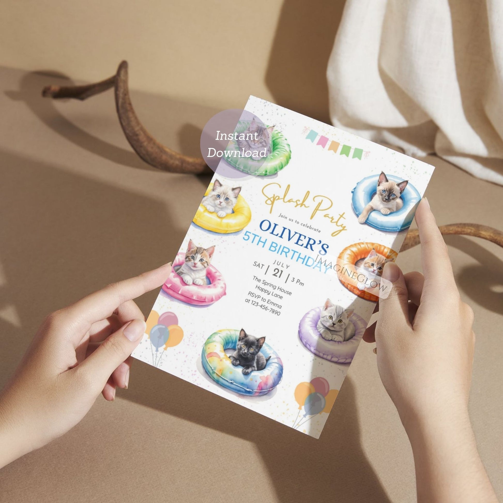 Person holding a birthday party invitation with cat-themed decorations on a neutral background