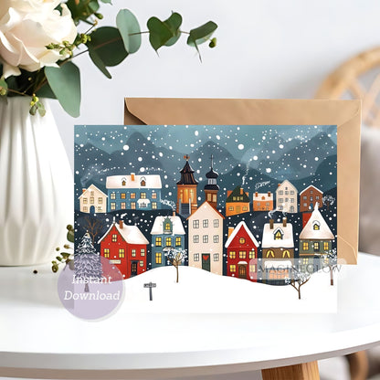 Greeting card with a winter village scene on a white surface with flowers.