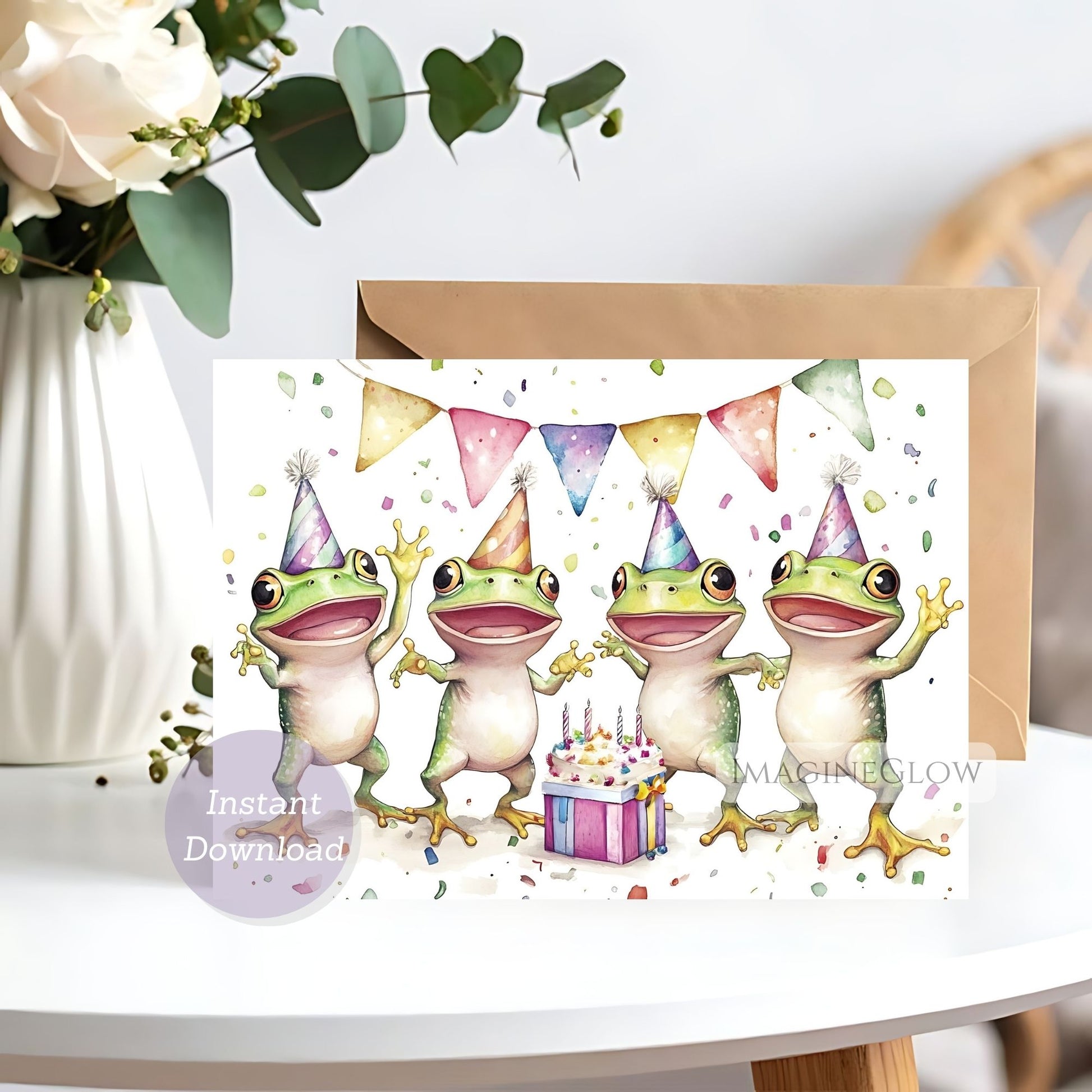 Card with cartoon frogs in party hats and a cake, with flowers in the background.