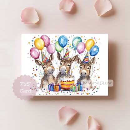 Birthday card with three donkeys, balloons, and a cake on a light pink background.