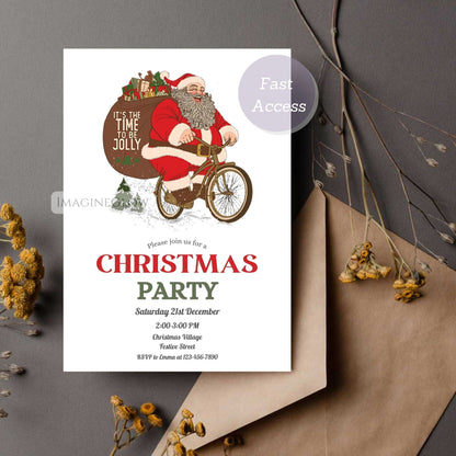 Christmas party invitation with Santa Claus on a bike, placed on a gray surface with decorative elements.